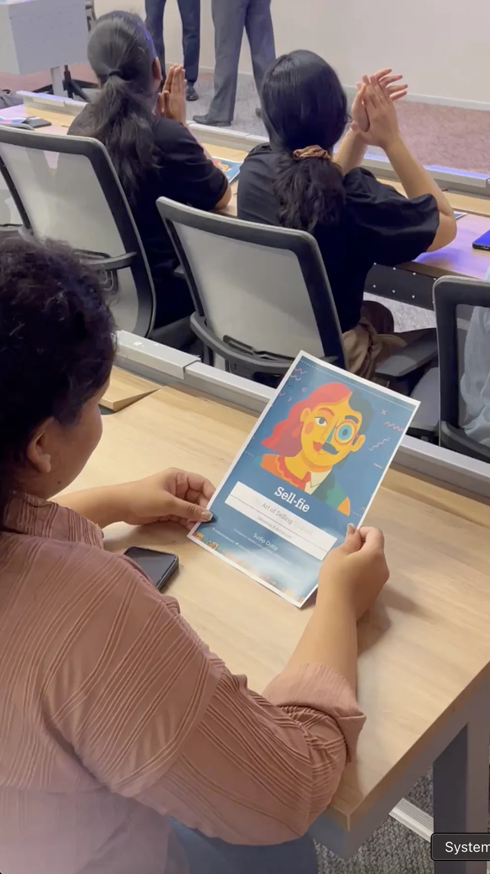 A participant holding Sell-fie session materials
